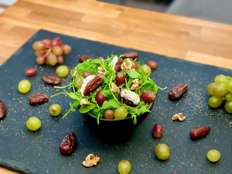Gefüllte Datteln mit Ziegenkäse auf Rucola-Trauben Salat - Box